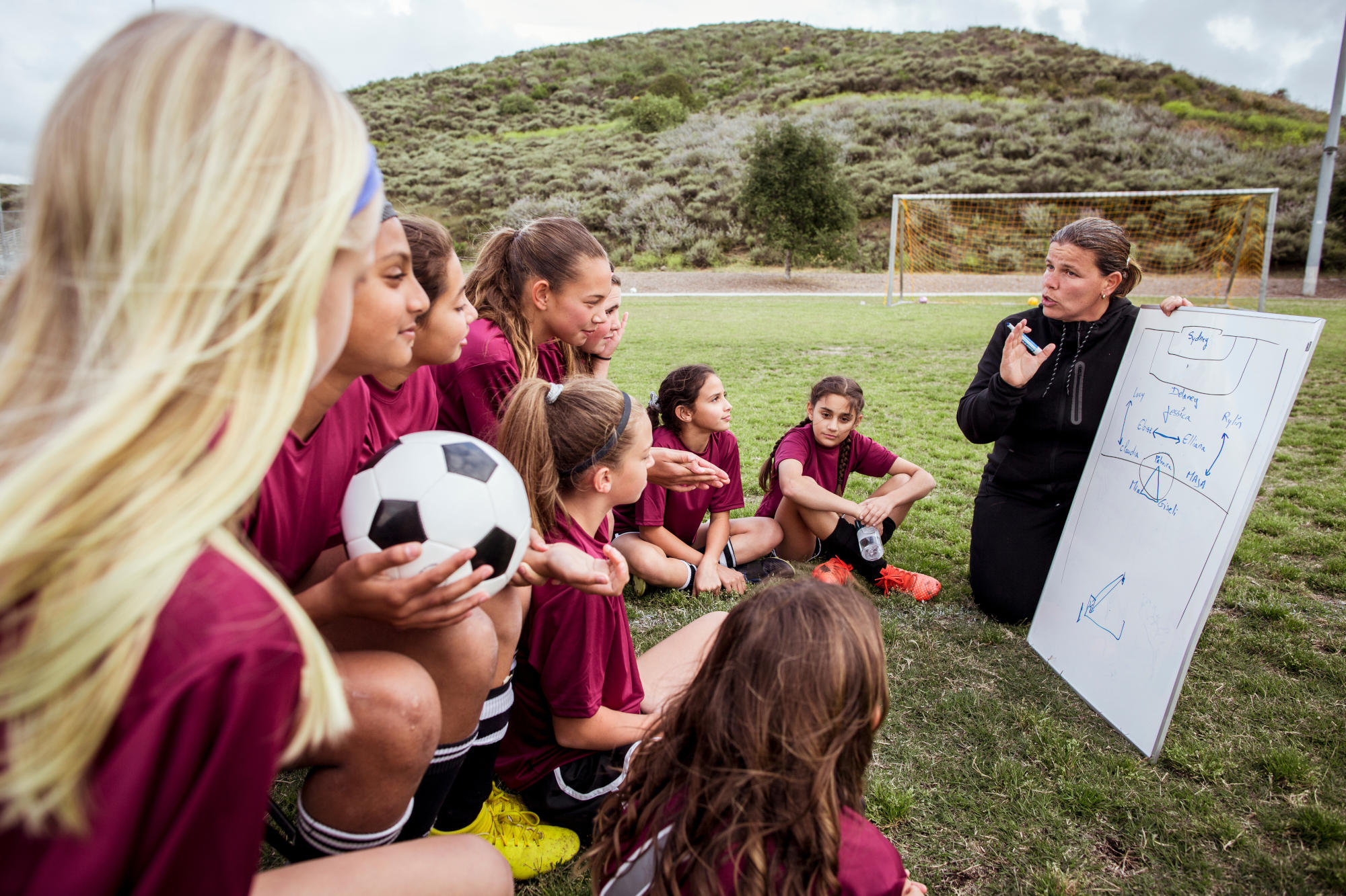 Players listening to coach in field