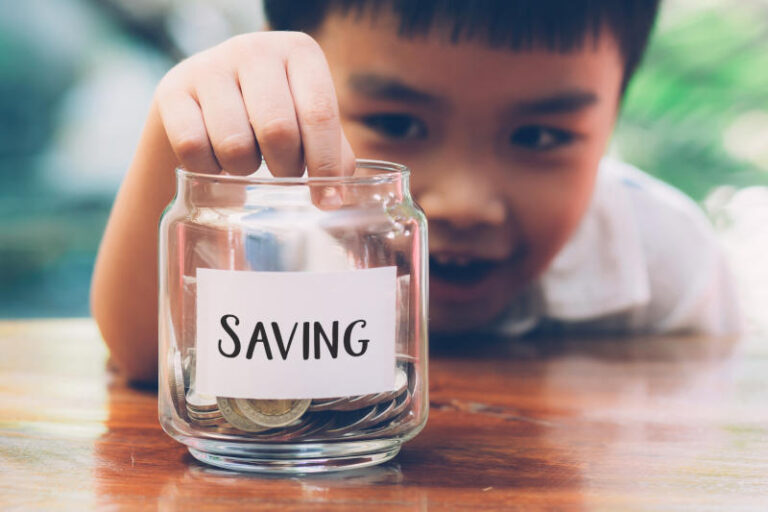 Happy asian children saving money putting coin in glass for wealth and growth of earning finance and investment for success boy planning and deposit business and economy concept banner website