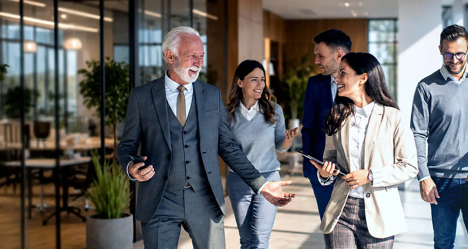 Family Business team collaborating in a modern office environment, embodying professional growth and organizational leadership - IMD Business School