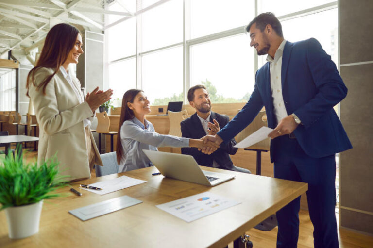 Business people shaking hands celebrating success or making a deal in office