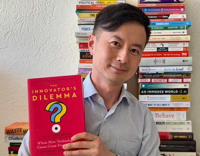 Howard Yu holding a book - IMD Business School