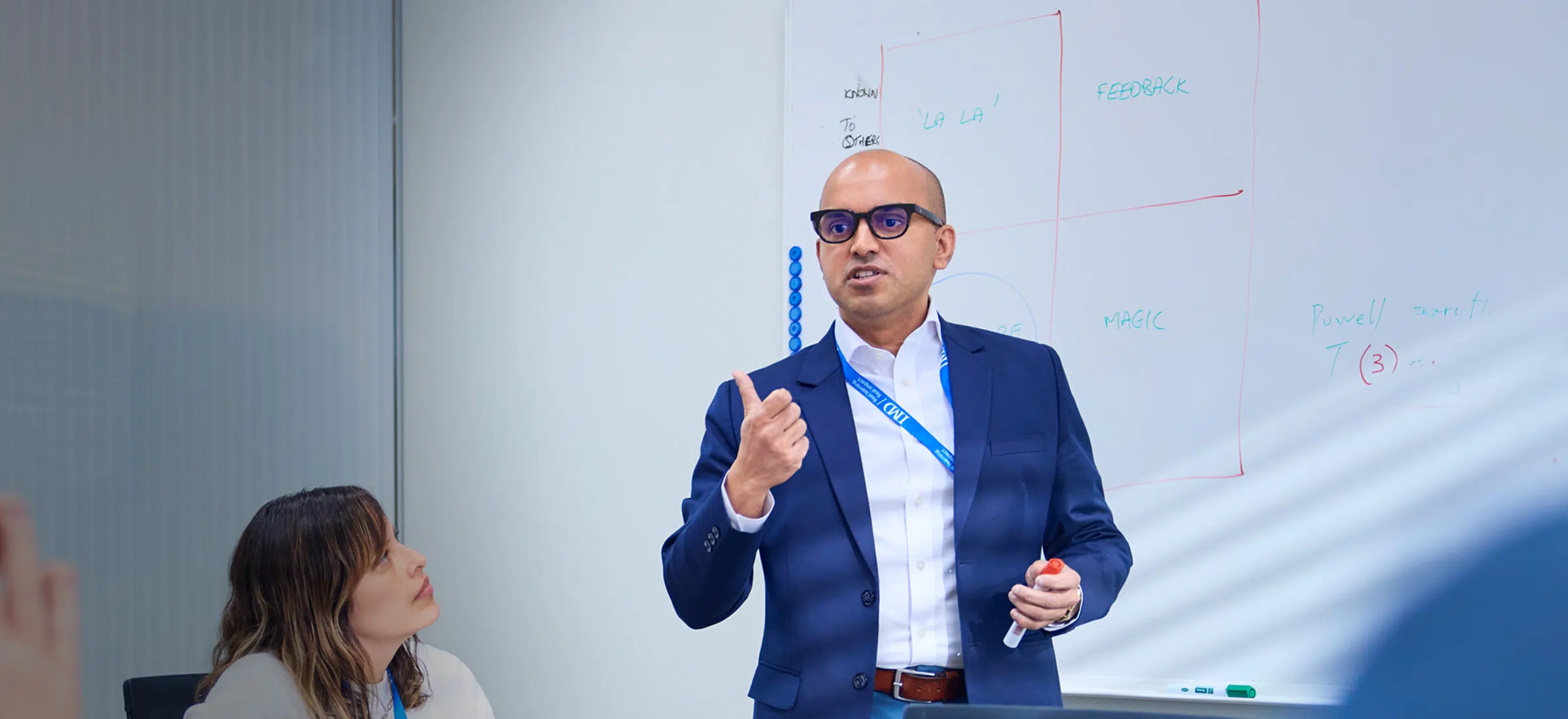 IMD EMBA student participants working together in a small group and presenting - IMD Business School