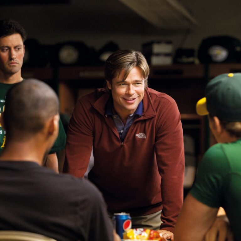 Locker room scene from Moneyball showing a coach leading his baseball team