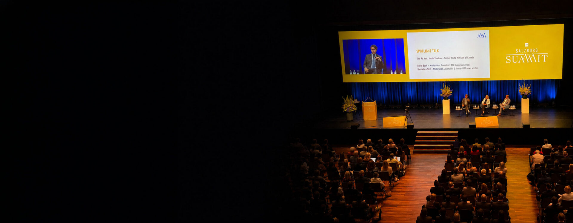 Audience attending a Salzburg Summit discussion featuring David Bach and Justin Trudeau on stage