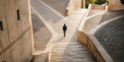 A person walks alone through intersecting stone paths and stairways, symbolizing the different directions a career can take