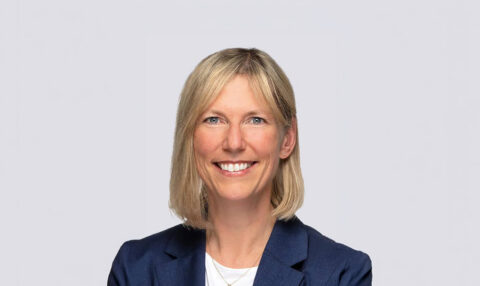 Smiling woman with shoulder-length blonde hair wearing a navy blazer, facing the camera (professional headshot).