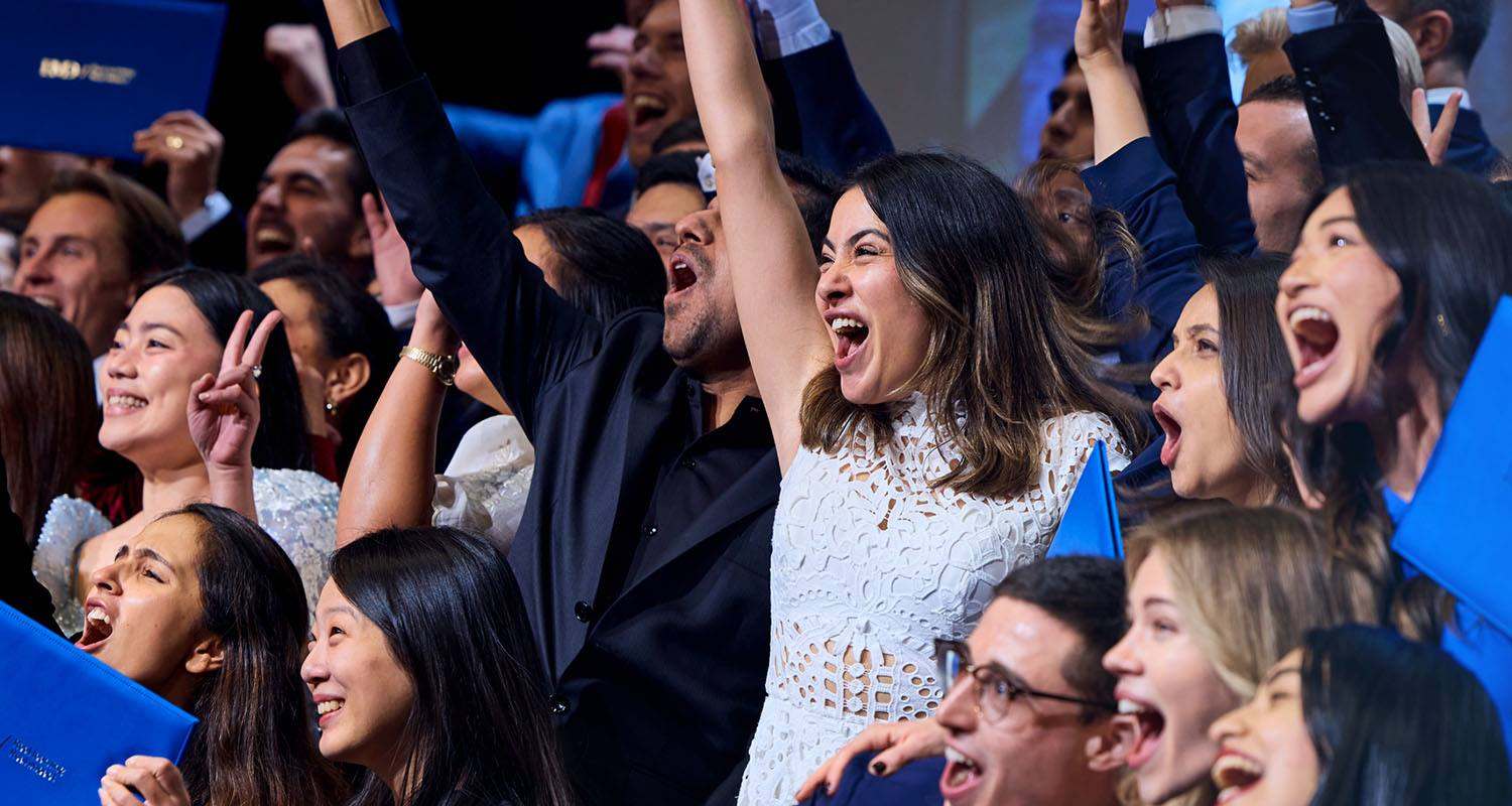 IMD Business School graduates celebrating together at their graduation ceremony. - IMD Business School