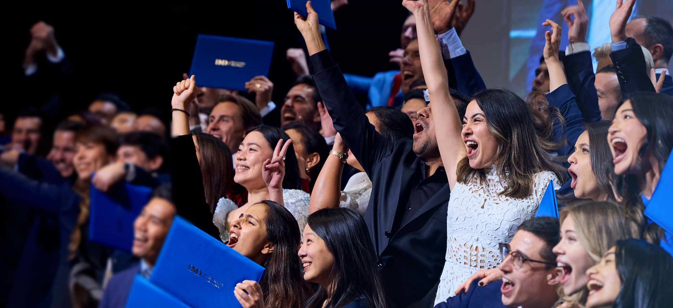 IMD Business School graduates celebrating together at their graduation ceremony. - IMD Business School
