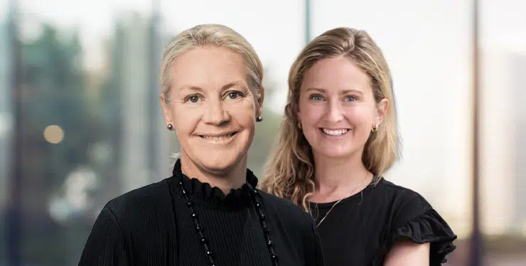 Two smiling women posing for a photo in a bright office setting, one slightly in front of the other. - IMD Business School