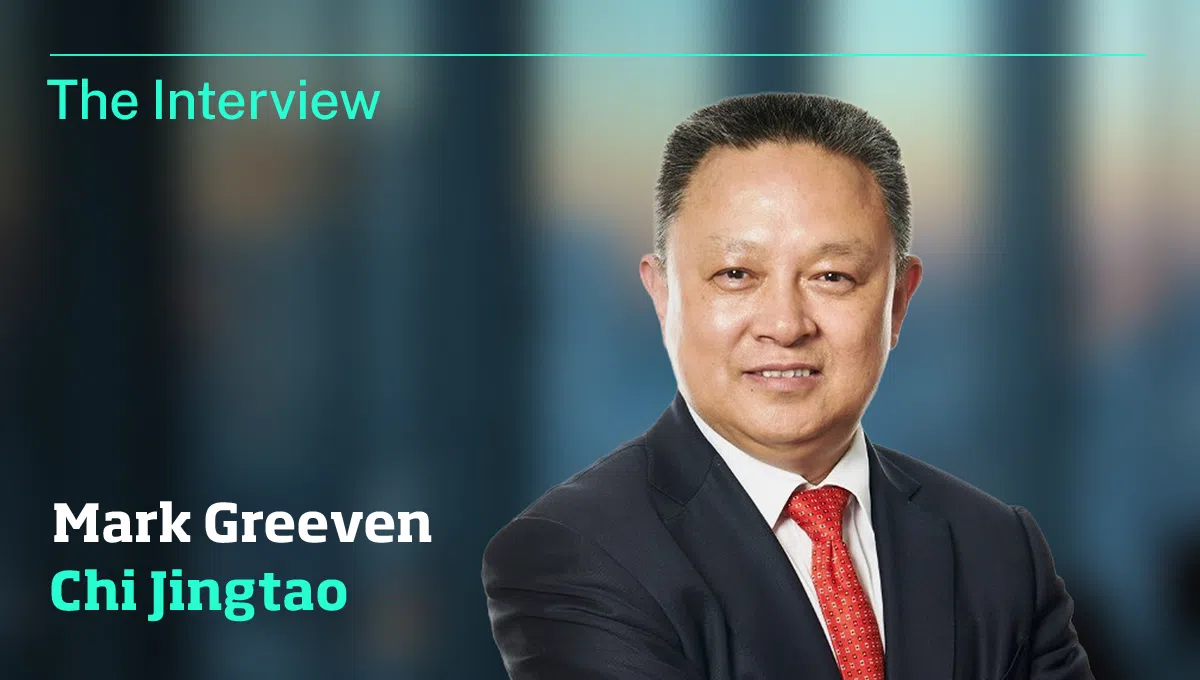 Portrait of Mark Greeven Chi Jingtao in a dark suit with a red tie, smiling, as a feature header reading 'The Interview'. - IMD Business School