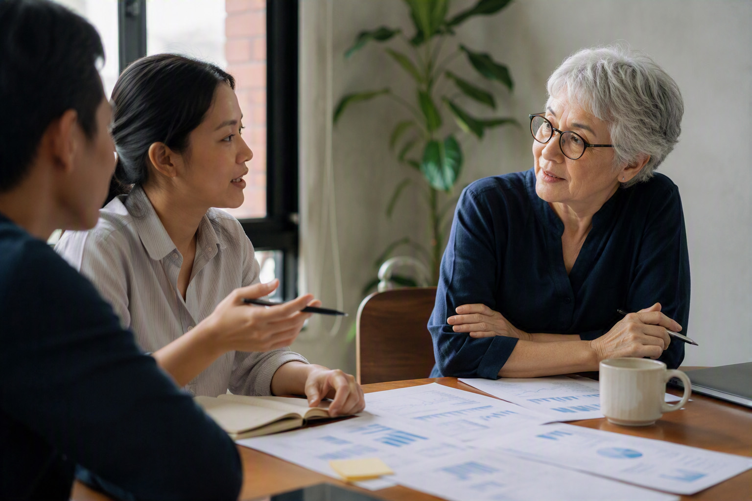 finance discussion captured at the moment of attentive engagement, showing how leaders build psychological safety by responding to questions and challenges with curiosity rather than defensiveness, encouraging employees to speak up and test assumptions