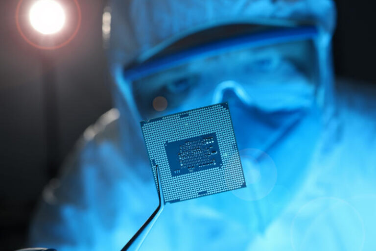 Man in mask suit and glasses hold electronic chip close-up with forceps