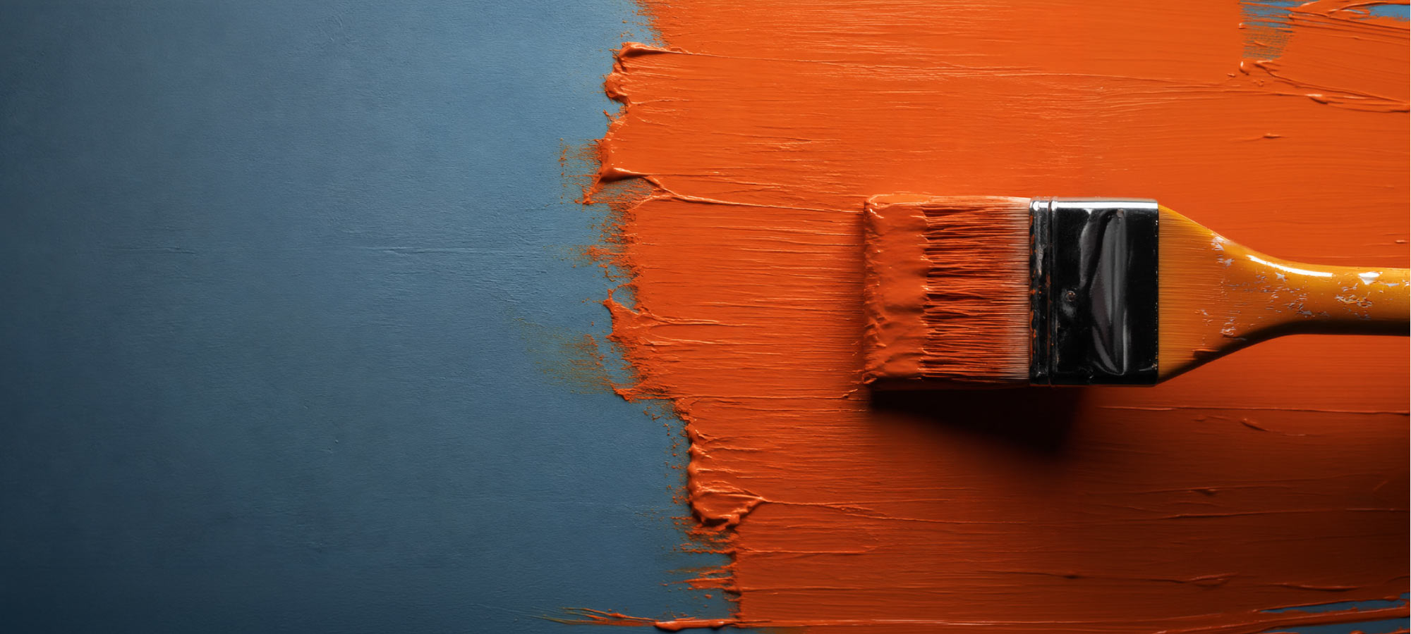 Blue wall being painted with orange paint