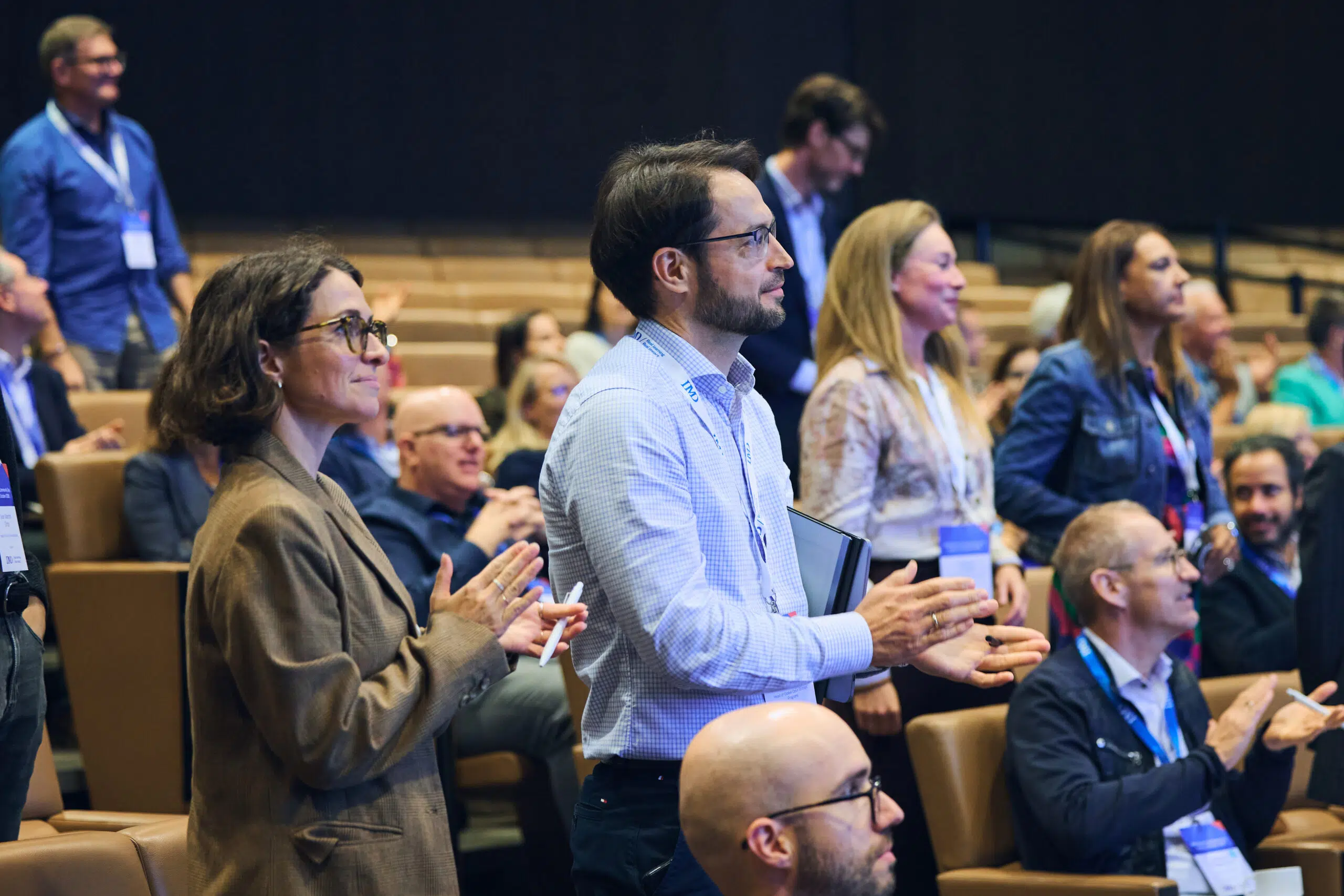 IMD Alumni Community leaders standing up in the auditorium - IMD Business School